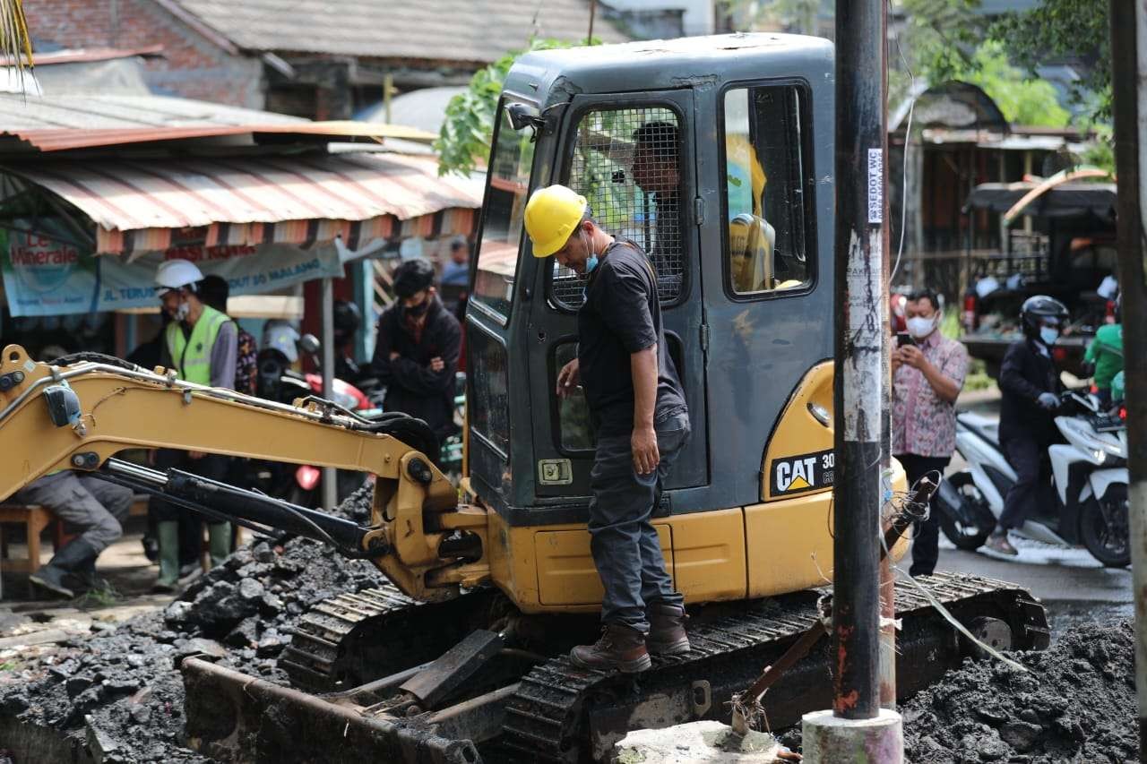 Proses pengerukan sampah dan sedimen di saluran kawasan Bukirsari, Kota Malang. (Foto: Istimewa)