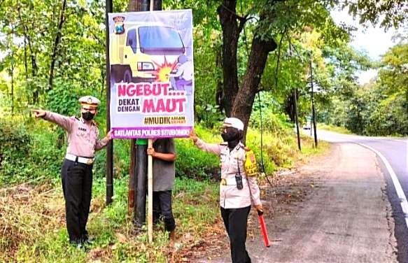 Kasat Lantas Polres Situbondo AKP Anindita Harcahyaningdyah pimpin pemasangan banner imbauan bagi pemudik Lebaran di Jalur Pantura Situbondo. (Foto: Dok Humas Polres Situbondo)