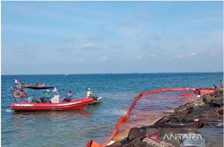 Petugas melokalisir area tumpahan minyak di kawasan Pantai Ujong Blang Lhokseumawe, Minggu 24 April 2022. (Foto: Antara/Dedy Syahputra)