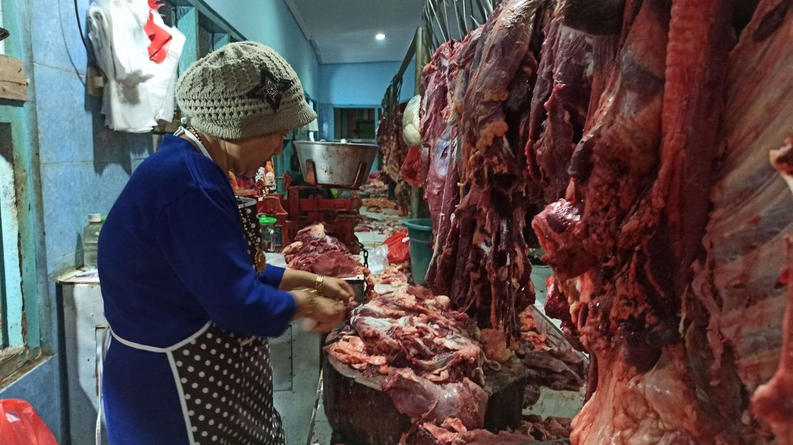 Pedagang daging di pasar Blambangan sedang melayani pembeli (foto: Muh Hujaini/Ngopibareng.id)