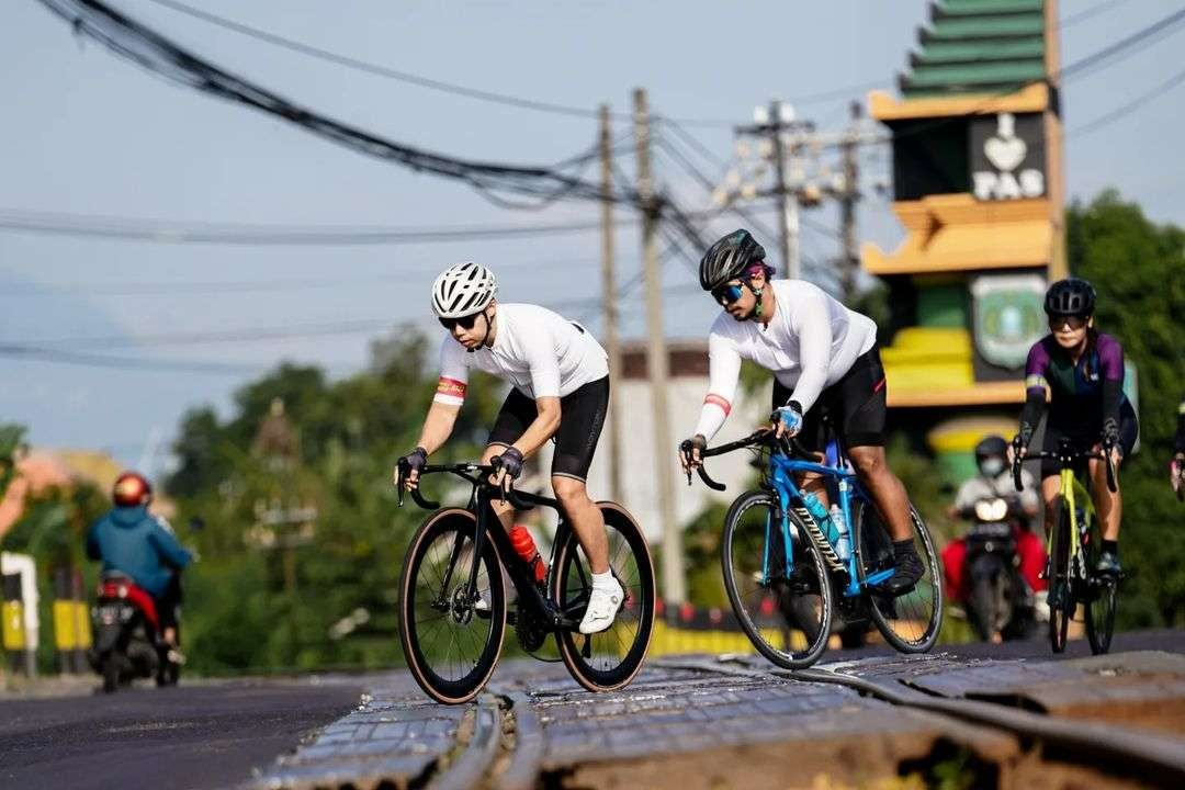 Budi Mirawan (depan) dan Satrio Hadi (helm hitam) melintasi rel kereta api dengan cara memotong rel tersebut. (Foto: Chaidar)