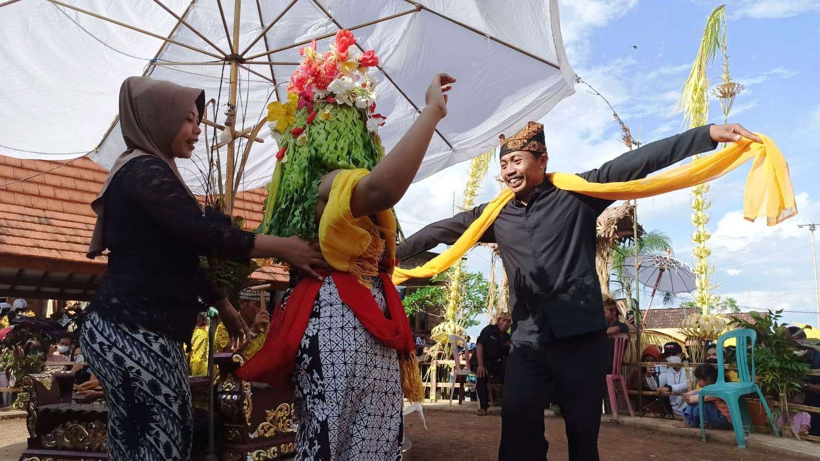 Penari Seblang Olehsari menari dengan didampingi seorang perempuan dari masyarakat adat. Dia menari mengelilingi panggung adat berbentuk bulat. (Foto: Muh. Hujaini/Ngopibareng.id)