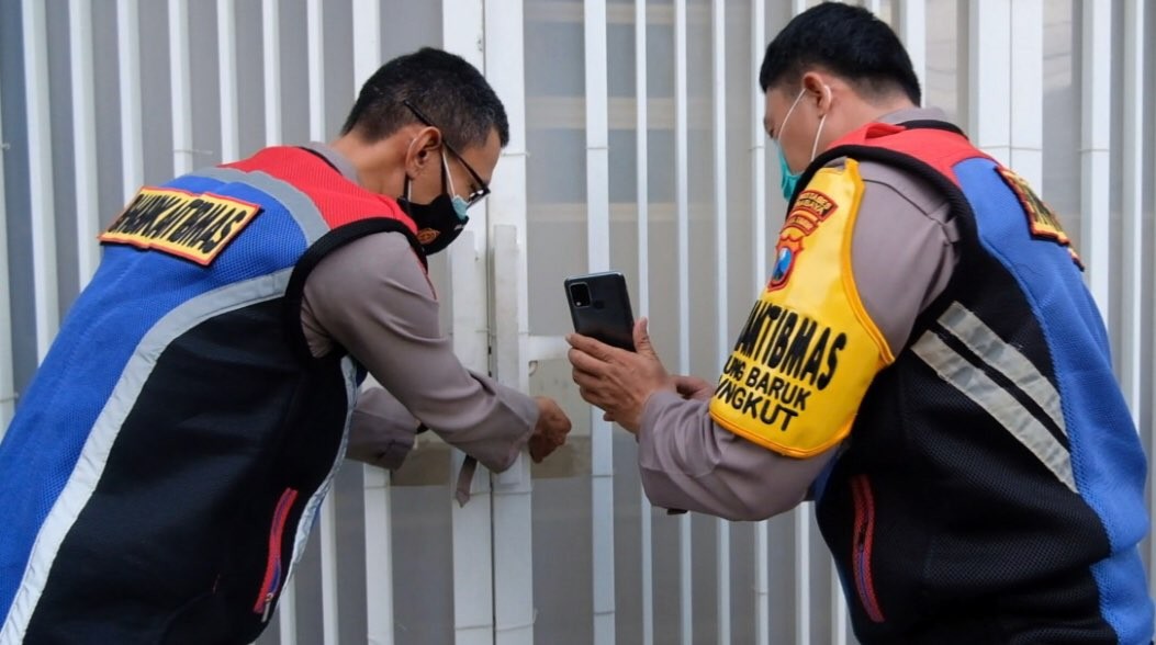 Anggota Polsek Rungkut saat menunjukkan rumah warga yang sedang mudik. (Foto: dok. Polsek Rungkut)