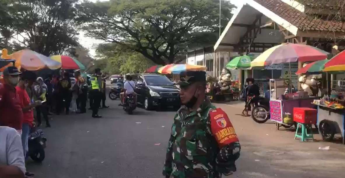 Personel polisi dan TNI tampak berjaga di lokasi kejadian jatuhnya 15 pengunjung kolam renang Kenjeran Park, Surabaya. (Foto: Tangkapan Layar)