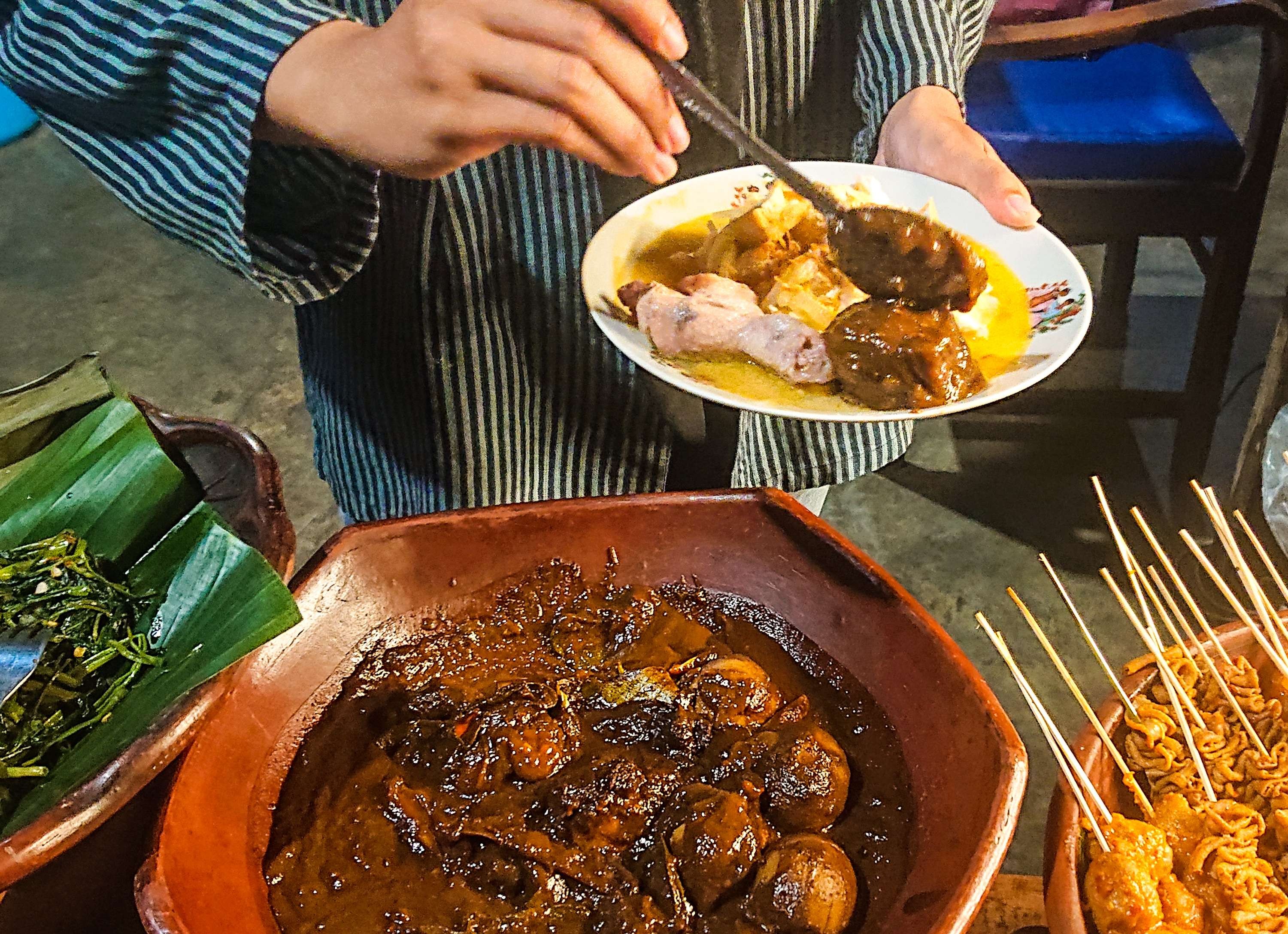 Pramusaji sedang meracik ketupat sayur. (Foto: Aini Arifin/Ngopibareng.id)