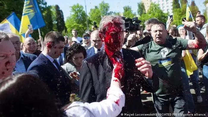 pengunjuk rasa anti-perang di Polandia melemparkan cat merah ke Duta Besar Rusia, Sergey Andreev, mencegahnya memberi penghormatan di pemakaman Warsawa kepada Tentara Merah yang tewas dalam Perang Dunia II. (Foto: dw.com)