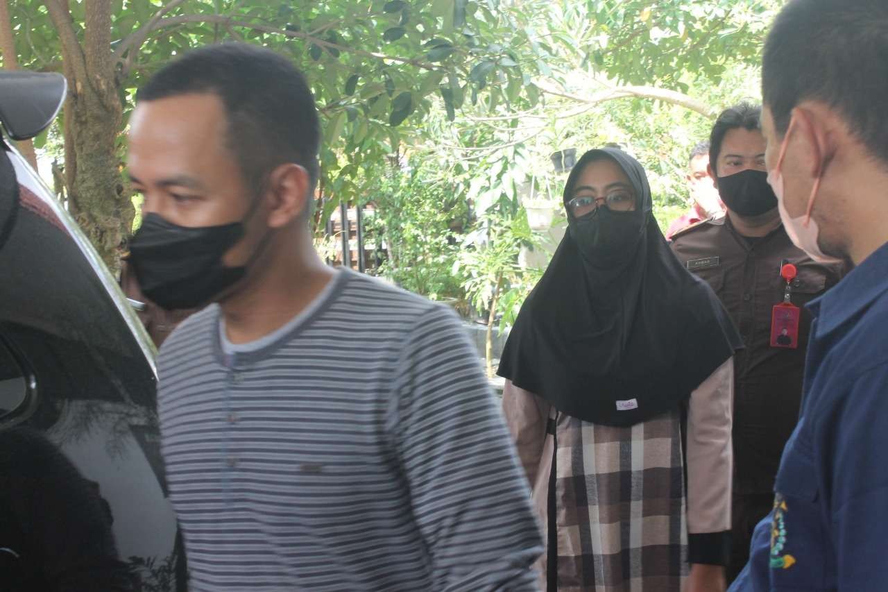 Oknum anggota polisi, tersangka dugaan kasus korupsi Rp3 miliar hendak memasuki mobil tahanan. (Foto: Ahmad Sampurno / Ngopibareng.id)