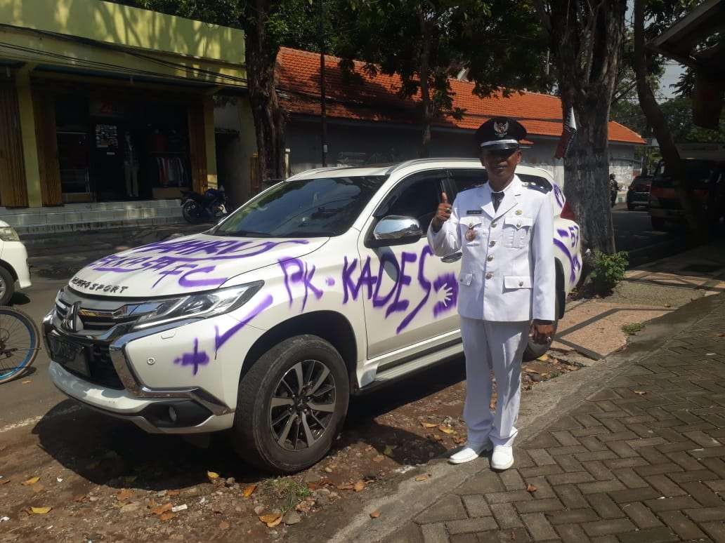 Mukhlis yang baru dilantik menjadi Kepala Desa bersama Pajeronya yang penuh coretan. (Foto: Istimewa)