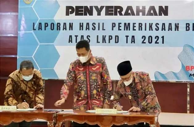 Ketua DPRD Bondowoso Ahmad Dhafir (kiri) dan Bupati Bondowoso Salwa Arifin (berkopiah), tanda tangan dokumen Opini WTP di kantor Perrwakilan  BPK RI Jatim, Sidoarjo. (Foto: Humas Protokol Bondowoso)