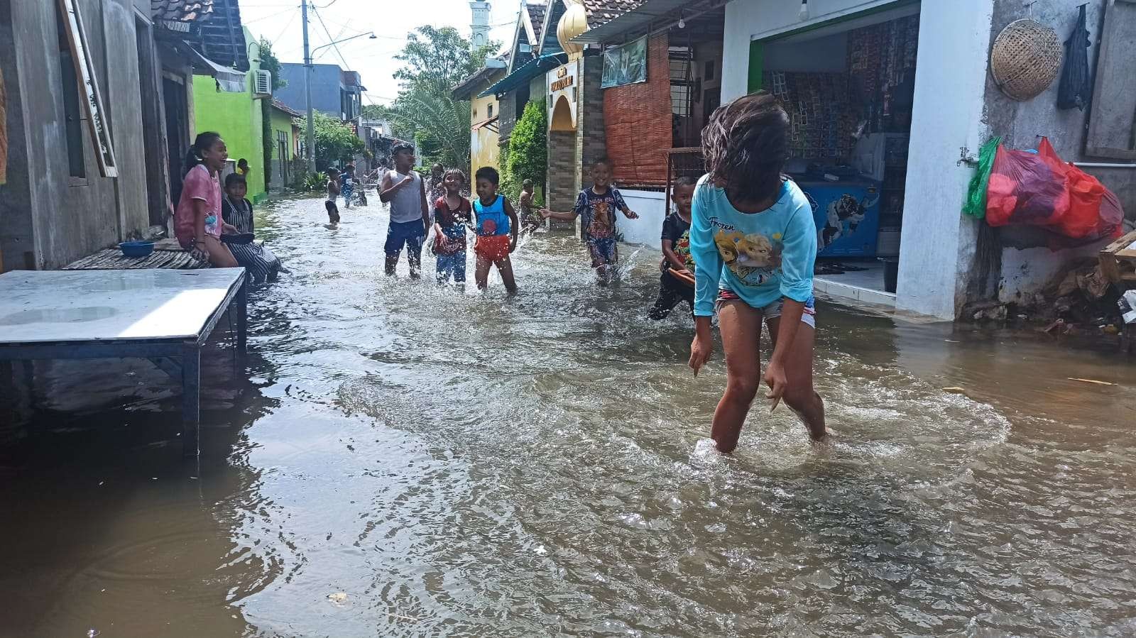 Beberapa anak-anak di lingkungan Ujung Kelurahan Kepatihan bermain di genangan air rob. (foto: Muh Hujaini/Ngopibareng.id)