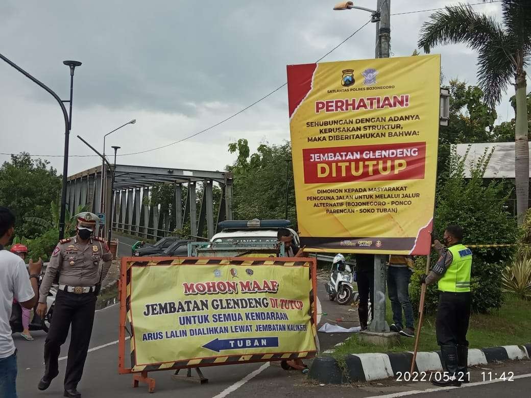 Kasatlantas Polres Bojonegoro AKP Rizal Nugra Wijaya ikut mengatur lalu lintas setelah penutupan Jembatan Glendeng penghubung Bojonegoro-Tuban, Sabtu 21 Mei 2022.(Foto: Sujatmiko/Ngopibareng.id)