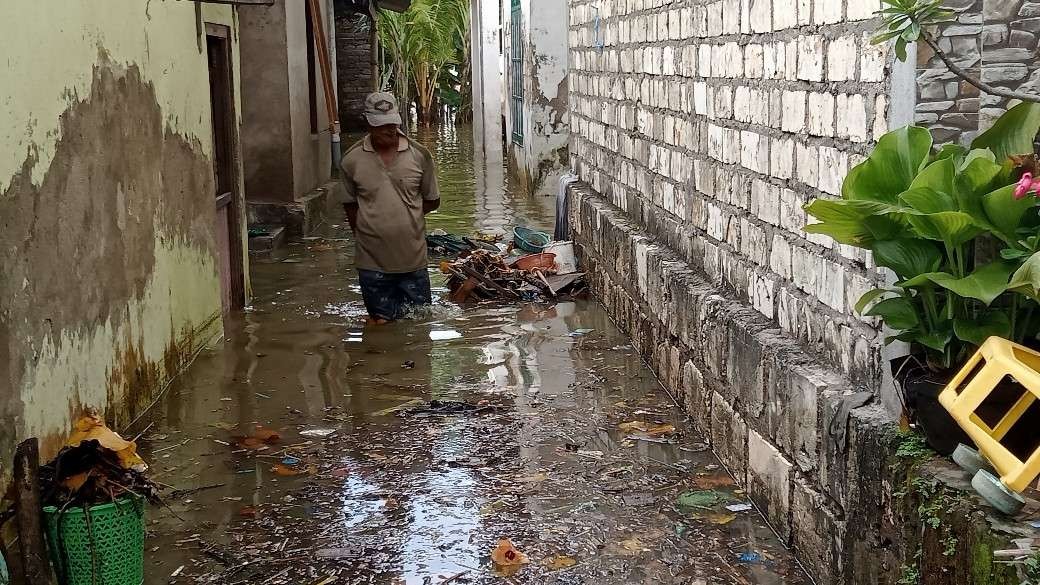 Warga Tuban saat melewati genangan banjir rob (Khoirul Huda/Ngopibareng.id)