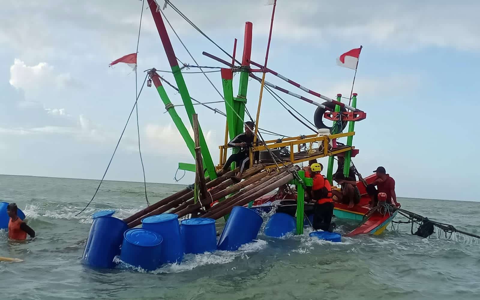 Petugas BPBD Kabupaten Tuban dibantu warga melakukan evakuasi perahu nelayan yang tenggelam (Foto: dok. BPBD Tuban)