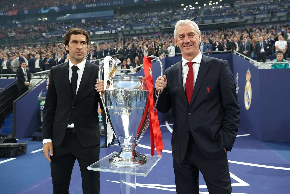 Raul Gonzales dan Ian Rush memegang trofi Liga Champions 2021/2022. (Foto: Twitter/@ChampionsLeague)