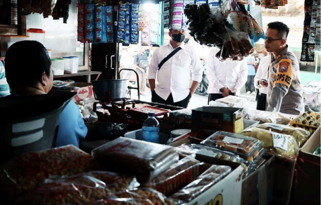 Kapolres Bondowoso AKBP Wimboko saat berbincang dengan penjual minyak goreng curah di Pasar Induk Kota lantai II. Harga minyak goreng di Bondowoso stabil. (Foto: Guido Saphan/Ngopibareng.id)