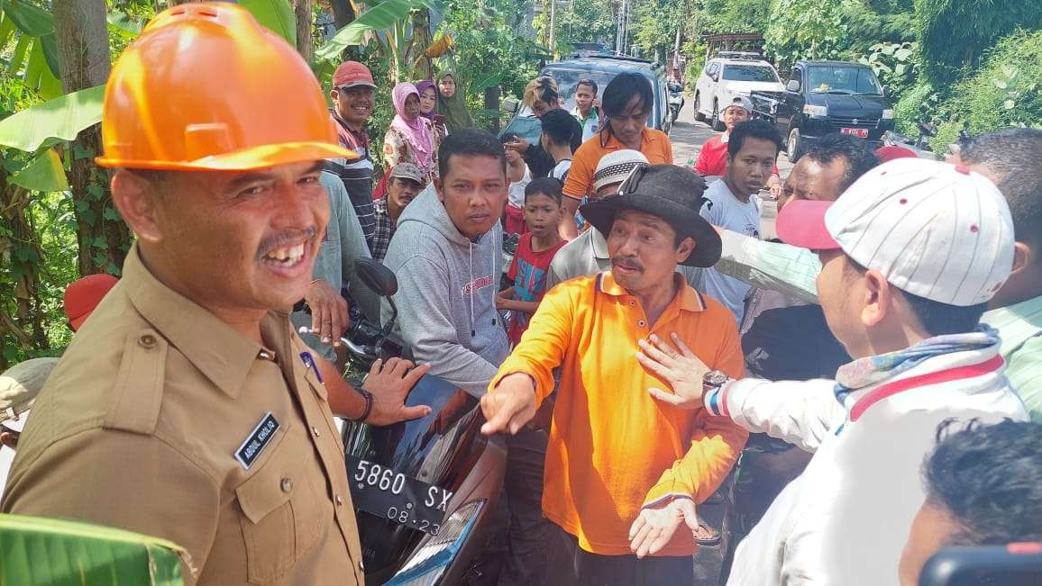 Kabid Perkim pada Dinas PUPR, Abdul Khalik (kanan) saat bersitegang Sadiono, warga yang memprotes proyek jalan. (Foto: Ikhsan Mahmudi/Ngopibareng.id)