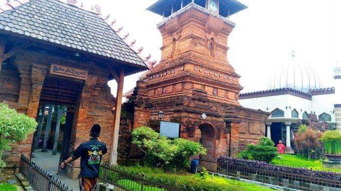 Selalu terbuka. Seorang peziarah melintasi gerbang depan kompleks Masjid Menara Kudus.(Foto: Istimewa)