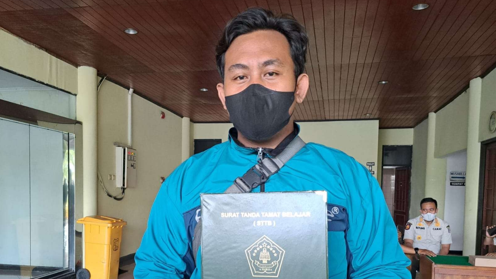 Dimas Hadi Saputra saat keluar membawa ijazah SMA-nya yang tertahan selama 2 tahun. (Foto: Pita Sari/Ngopibareng.id)