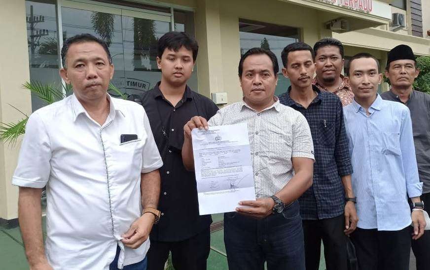 Anip Hariyadi didampingi pengacaranya menunjukkan bukti Laporan yang disampaikan ke Polresta Banyuwangi (foto: Muh Hujaini/Ngopibareng.id)