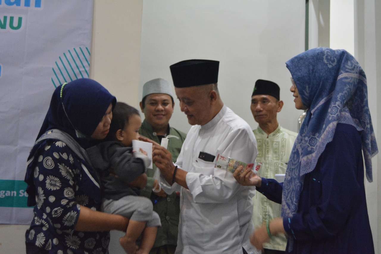 H. Noor Shodiq Askandar, inisiator Rumah Sedekah NU saat menyerahkan bantuan pada yatim piatu. (Foto: Istimewa)