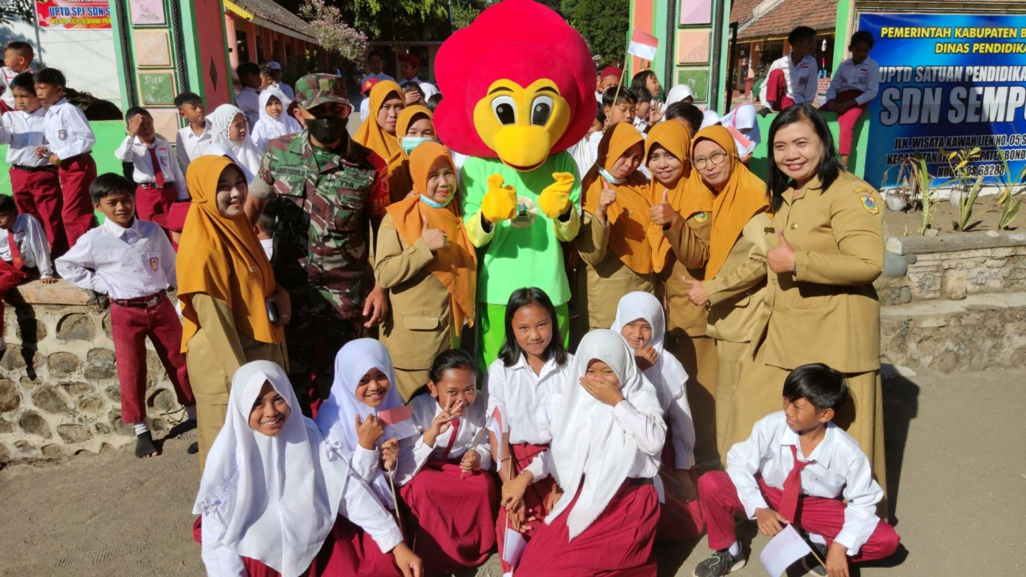 Siswa dan Guru SDN Sempol I berfoto bersama maskot Porprov VII Jatim Cak Beki, saat kirab api dan maskot di Kabupaten Bondowoso, Senin 20 Juni 2022. (Foto: Fariz Yarbo/Ngopibareng.id)