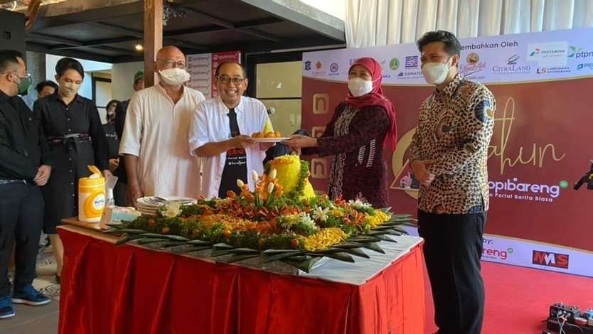 Gubernur Jawa Timur Khofifah Indar Parawansa saat memberikan potongan tumpeng kepada CEO Ngopibareng.id.