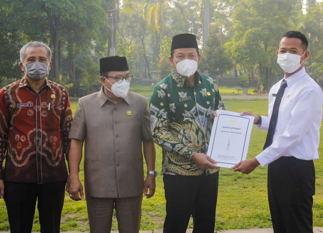 Wabup Subandi (batik hijau) serahkan SK PPPK kepada salah satu guru. (Foto: Aini/Ngopibareng.id)