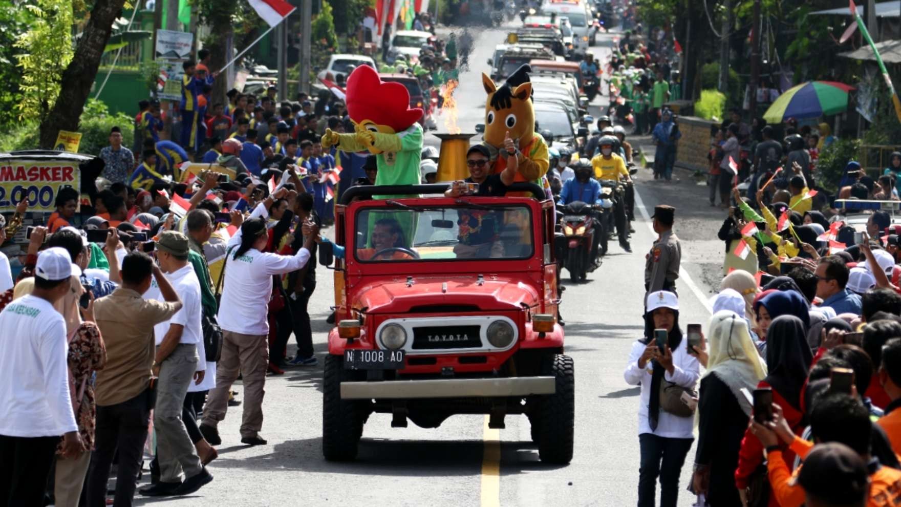 Masyarakat Lumajang tumpah ruah di jalanan menyambut kirab api Porprov VII Jatim 2022, Kamis 23 Juni 2022. (Foto: Fariz Yarbo/Ngopibareng.id)