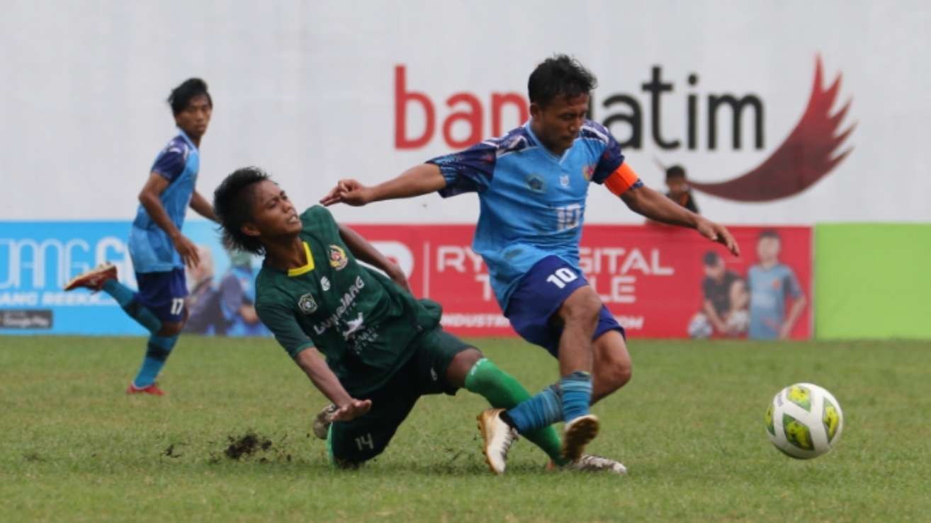 Pemain Lumajang Firgiawan Dwi (hijau) mencoba menghalau pergerakan pemain Lamongan, Imas Tri Pamungkas dalam laga Porprov VII Jatim 2022 di Stadion Semeru, Lumajang, Kamis 23 Juni 2022. (Foto: Fariz Yarbo/Ngopibareng.id)