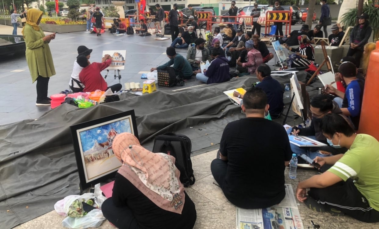 Para pelukis yang memilih sudut Balai Pemuda untuk memudahkan mereka melihat objek (Foto: Andhi Dwi/Ngopibareng.id)