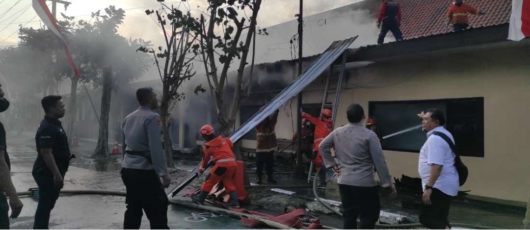 Para petugas pemadam kebakaran dibantu polisi memadamkan kobaran api yang membakar gudang logistik Polres Kediri Kota. (Foto: Fendhy Plesmana/Ngopibareng.id)