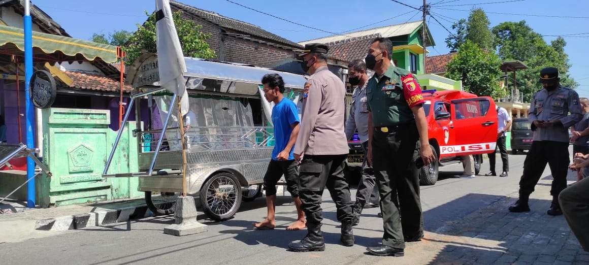 Petugas dan warga di lokasi depan rumah Riyono yang tewas ditusuk istrinya sendiri. (Foto: Fendhy Plesmana/Ngopibareng.id)