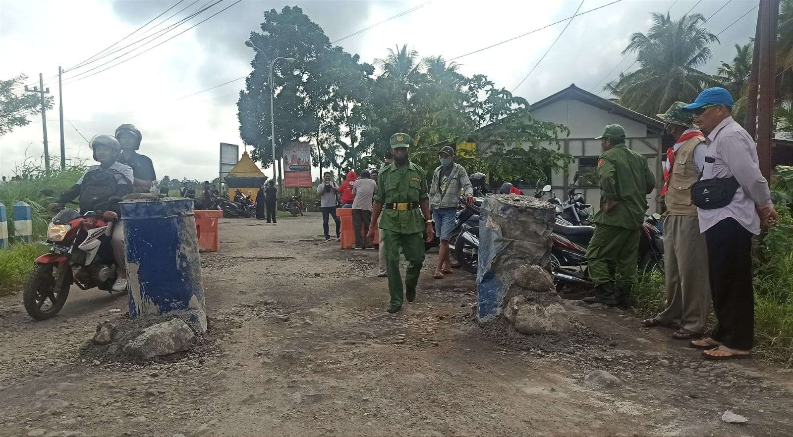 Warga dan petugas Linmas Desa Cantuk menjaga jalan di perbatasan untuk memastikan tidak ada dump truk overkapasitas melintas (foto:Muh Hujaini/Ngopibareng.id)