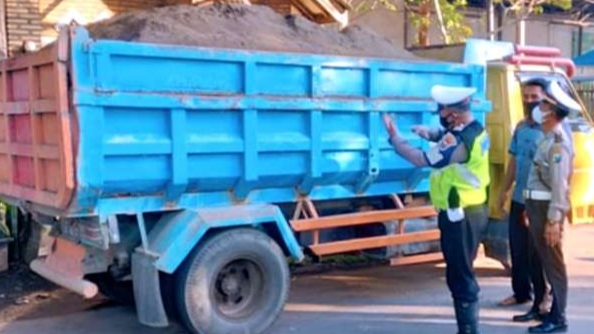 Anggota Satlantas Polres Bondowoso menghentikan dan menegur truk angkut pasir tanpa penutup, karena mengganggu pengguna jalan lainnya. (foto: Satlantas Polres Bondowoso)