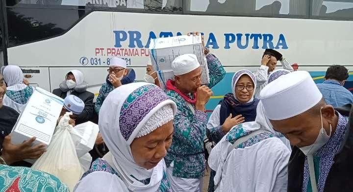 Jemaah haji asal Kabupaten Tuban saat turun dari bus di lokasi penjemputan di Kompi Senapan C421 Tuban (Khoirul Huda/Ngopibareng.id)