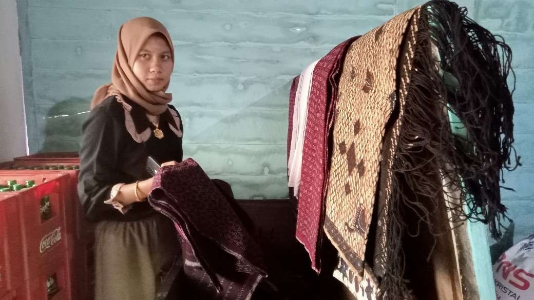 Calon pengantin wanita menunjukkan kain batik gedog seserahan dari keluarga calon pengantin pria (Foto: Khoirul Huda/Ngopibareng.id)