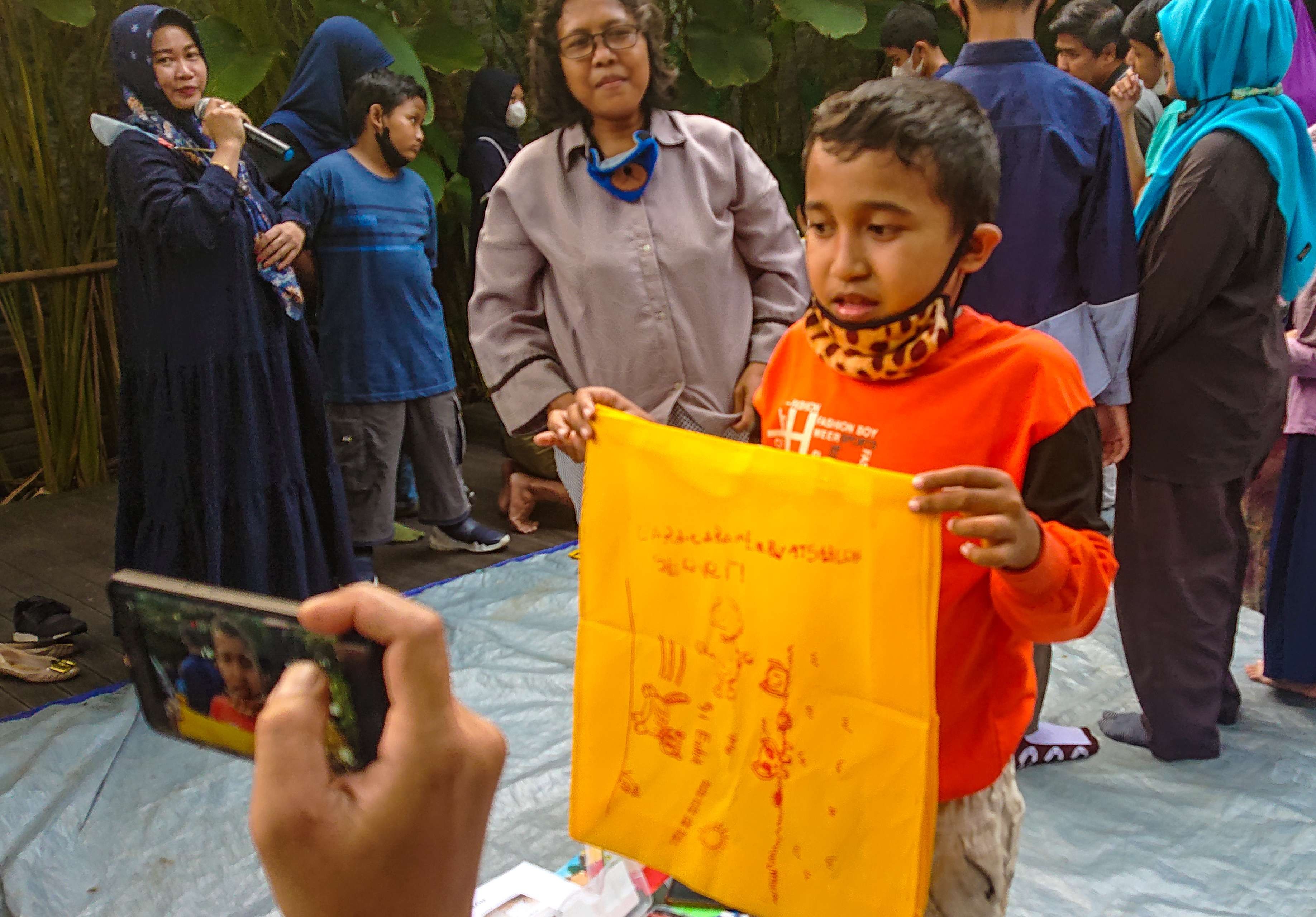 Salah satu peserta anak difabel menunjukkan hasil karya sablonnya. (Foto: Aini/Ngopibareng.id)