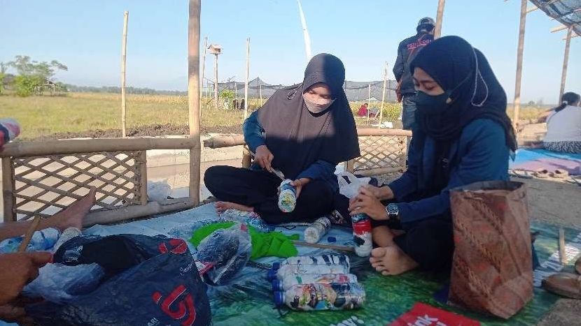 Mahasiswa Undip memasukkan plastik ke dalam botol untuk membuat ekobrik (Foto: Ahmad Sampurno/ Ngopibareng.id)