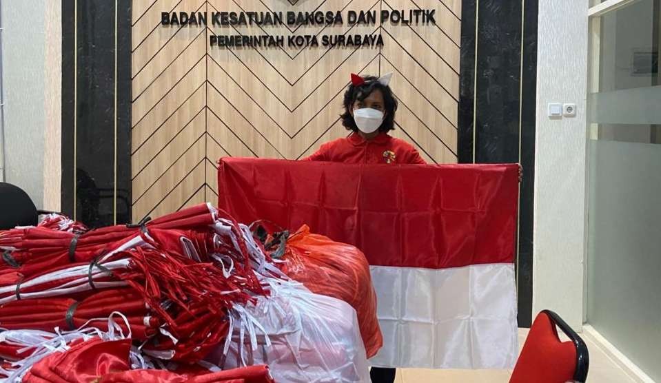 Kepala Badan Kesatuan Bangsa dan Politik (Bangkesbangpol), Maria Theresia Ekawati Rahayu saat menunjukkan bendera yang dibagikan. (Foto: Pita Sari/Ngopibareng.id)