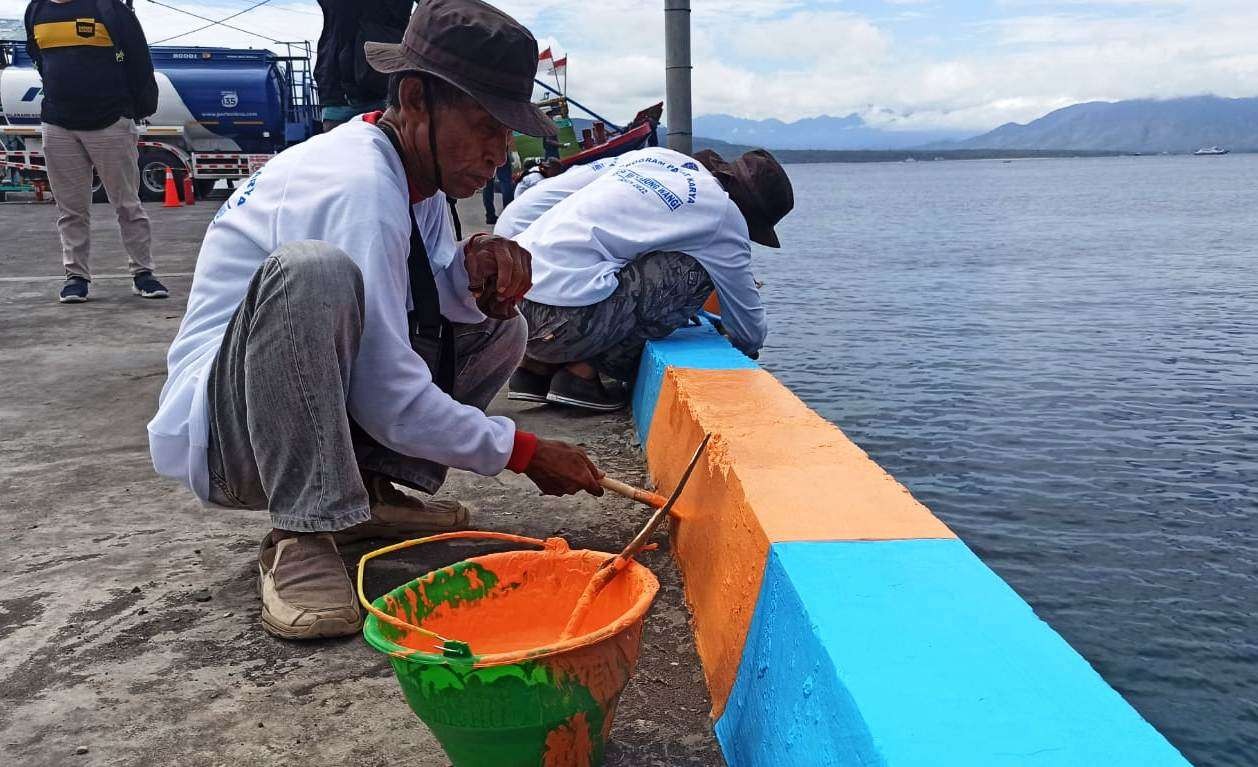 Sejumlah warga sekitar Pelabuhan Tanjungwangi mengecat dermaga dalam program padat karya di Pelabuhan Tanjungwangi, Banyuwangi (foto:Muh Hujaini/Ngopibareng.id)