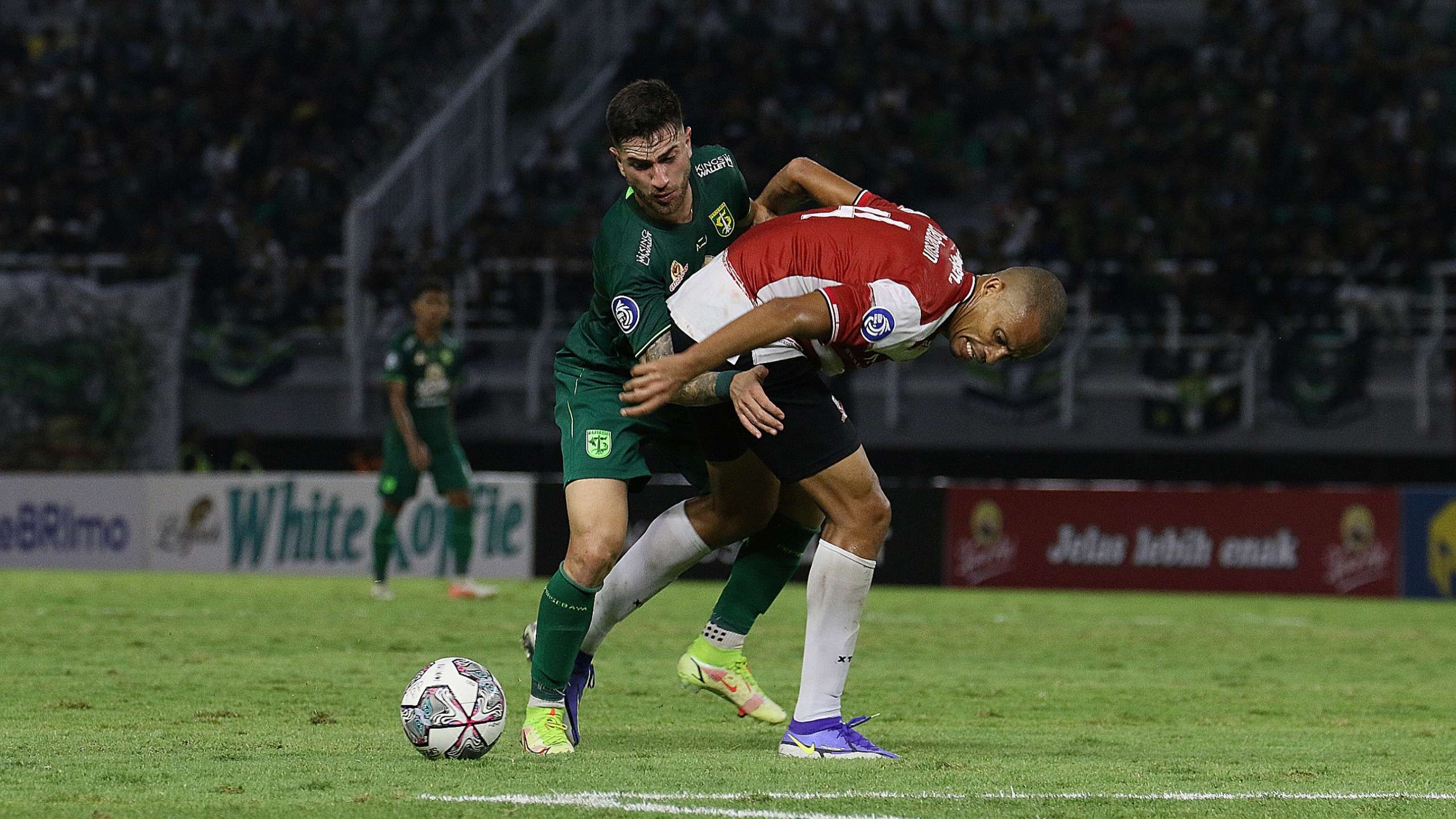 Pemain Madura United, Cleberson (merah) saat menjaga Pemain Persebaya Higor Vidal (hijau) di Stadion Gelora Bung Tomo, Surabaya, Minggu 14 Agustus 2022. (Foto: Fariz Yarbo/Ngopibareng.id)