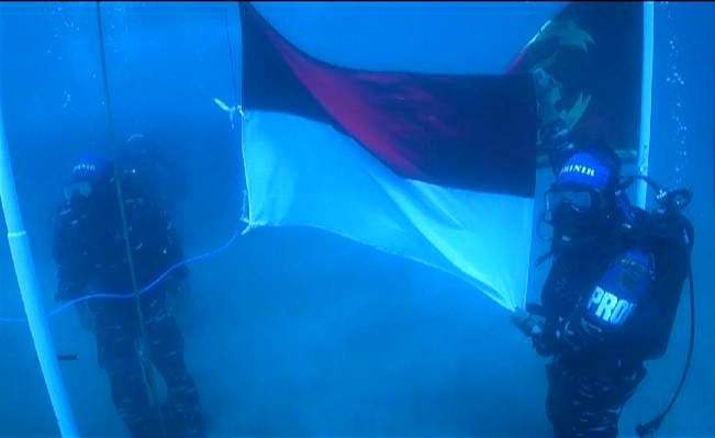 Prajurit Pasukan Marinir (Pasmar) 2 TNI AL upacara pengibaran bendera merah putih di Dasar Laut Pasir Putih Situbondo.(Foto: Dispen Kormar)