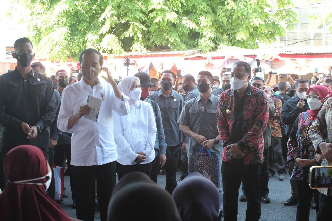 Presiden Jokowi bersama ibu Iriana saat memberikan bantuan langsung untuk warga di Pasar Pucang. (Foto: Humas Pemkot Surabaya)