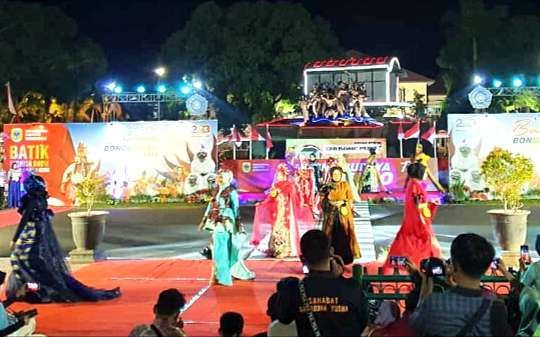 Ibu-ibu PKK dan Dharma Wanita Pemkab Bondowoso peragakan rancangan busana batik dalam fashion show di depan Monumen Gerbong Maut. (Foto: Guido Sapha/Ngopibareng.id)