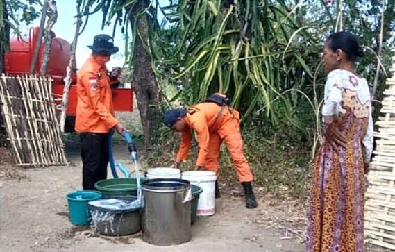 Petugas BPBD Bondowoso saat dropping air bersih di Kecamatan Botolinggo. (Foto: Guido Saphan/Ngopibareng.id)