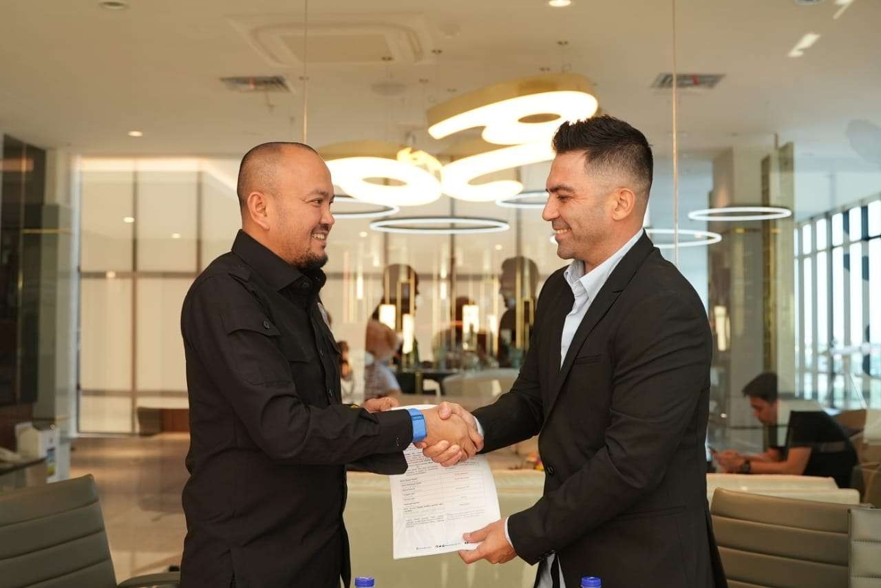 Manager Arema FC, Ali Rifki (kanan) dan pelatih baru Arema FC, Javier Roca (kiri) berjabat tangan usai penandatanganan kontrak. (Foto: Media Officer Arema FC)