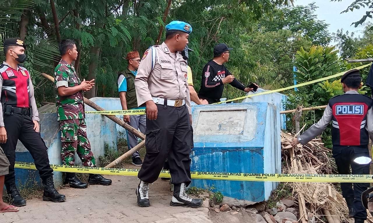 Polisi memasang penghalang dari bambu dan garis polisi di kaki jembatan gantung yang ambruk. (Foto: Ikhsan Mahmudi/Ngopibareng.id)