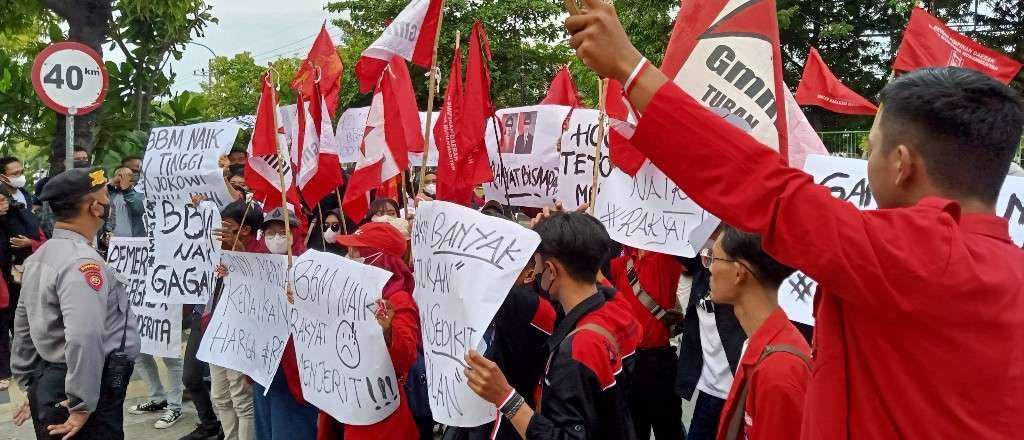 Aliansi Mahasiswa Tuban membentangkan poster saat melakukan aksi penolakan harga BBM di depan gedung DPRD Tuban (Foto: Khoirul Huda/Ngopibareng.id)