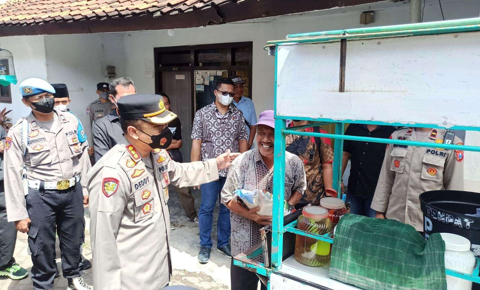 Kapolresta Banyuwangi Kombespol Deddy Foury Millewa berbincang dengan Suyono usai memberikan bantuan sembako (foto:Muh Hujaini/Ngopibareng.id)