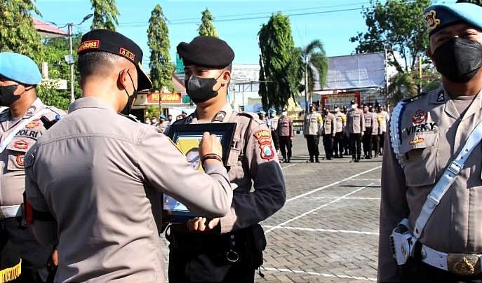 Kapolres Situbondo, AKBP Andi Sinjaya Ghalib mencoret foto Bripka Indra Sugiarto dalam upacara PTDH di Mapolres Situbondo, Senin 19 September 2022.(Foto: Guido Saphan/Ngopibareng.id)